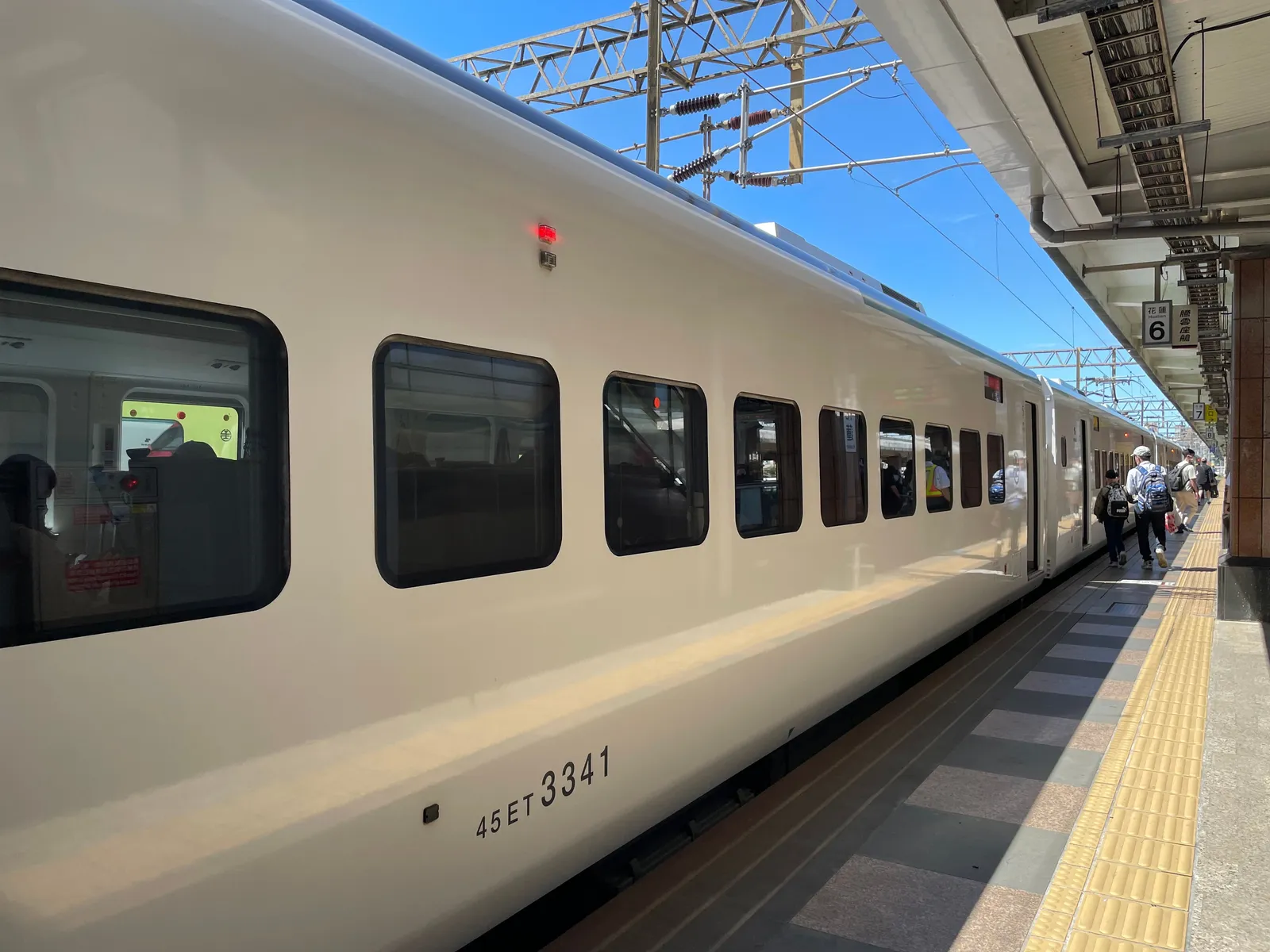 רכבת נוסעים עוצרת ברציף תחנה באור יום