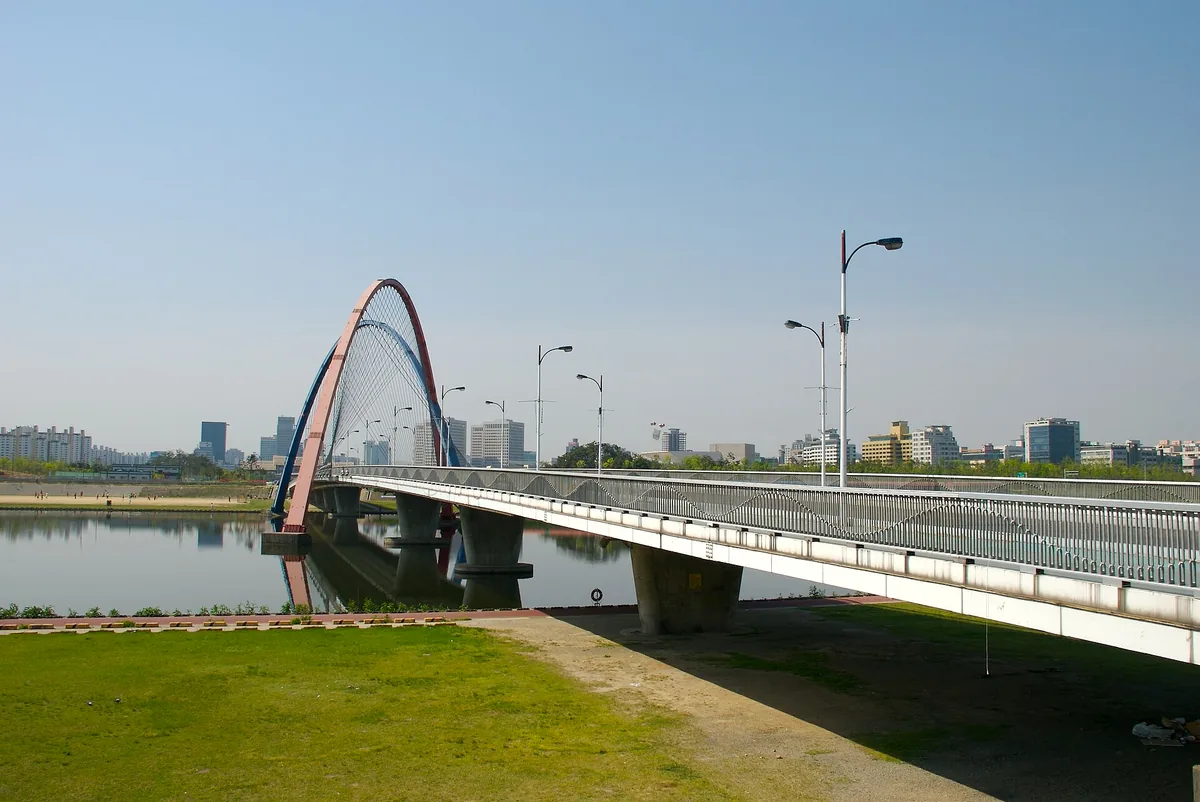 גשר האקספו עם קשת הפלדה האדומה שלו מעל הנהר בדג׳ון, בשמים בהירים